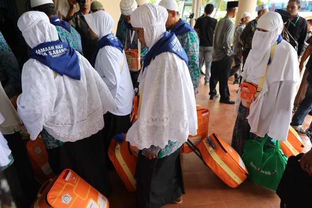 Jemaah calon haji embarkasi Aceh memasuki Aula Arafah Asrama Haji di Banda Aceh begitu turun dari bus untuk mendapatkan arahan dari petugas haji, Jumat (19/7). Foto: Husaini/acehkini 