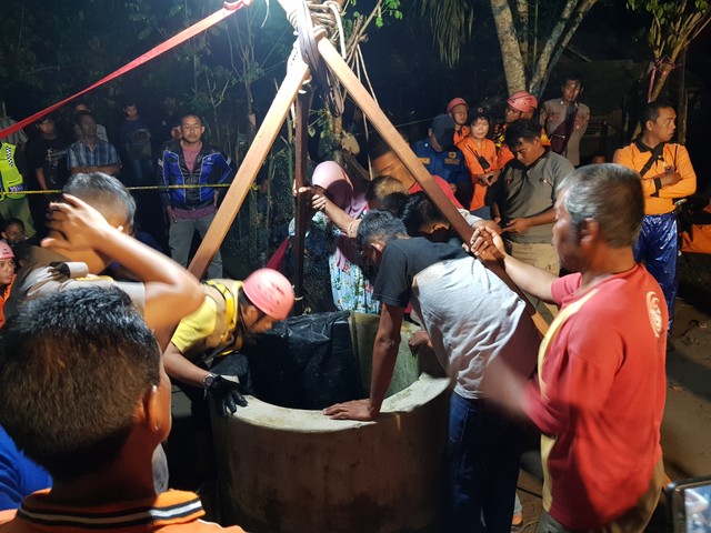 Pihak keluarga bersama Tim Gabungan SAR saat membujuk korban untuk naik ke atas. (Foto: Joko Hardyono)