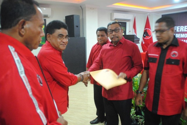 Ketua DPP PDIP Bidang SDM dan Pembangunan, Andreas Hugo Pariera, menyerahkan Surat Keputusan (SK) kepada Ketua DPD PDIP Maluku terpilihnya Murad Ismail dalam Konferda yang berlangsung di Hotel Pacifik Ambon, Minggu (21/7). (Foto: ambonnesia.com)