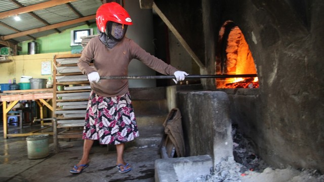 Salah satu ibu sedang mengeluarkan bara api. Tempat bagea dimatangkan. Foto: Gustam Jambu/cermat