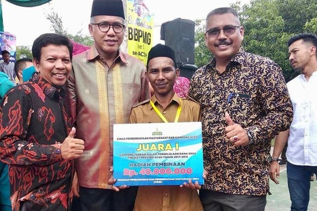 Keuchik Munirwan berpose bersama Plt Gubernur Aceh saat desa yang dipimpinnya terpilih sebagai Juara I Gampong Terbaik Dalam Pengelolaan Dana Desa Tingkat Provinsi Aceh tahun 2017/2018. Foto: Dok. Facebook Tgk Munirwan