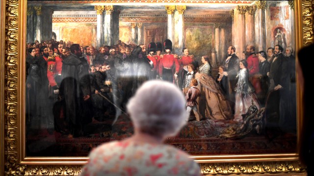 Ratu Elizabeth II melihat lukisan Ratu Victoria yang sedang memeriksa Pengawal Coldstream yang terluka, 1855, oleh John Gilbert, di Istana Buckingham Istana di London, Inggris. Foto: Getty Images