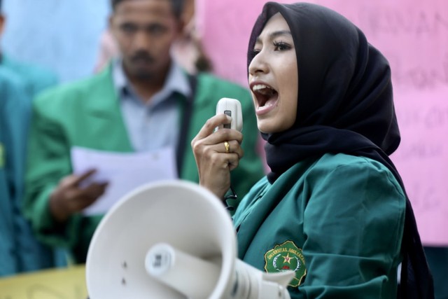 Koordinator Aksi, Rahmatun Phounna, saat berorasi dalam aksi demonstrasi di depan Kantor Dinas Pertanian dan Perkebunan Aceh, Jumat sore (26/7). Foto: Suparta/acehkini