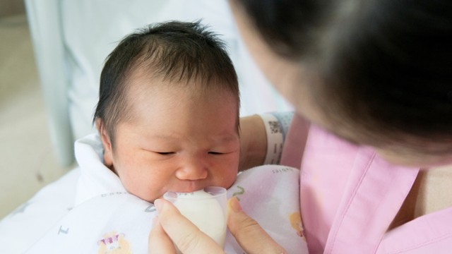 bayi minum ASI perah dengan gelas sloki Foto: Shutterstock