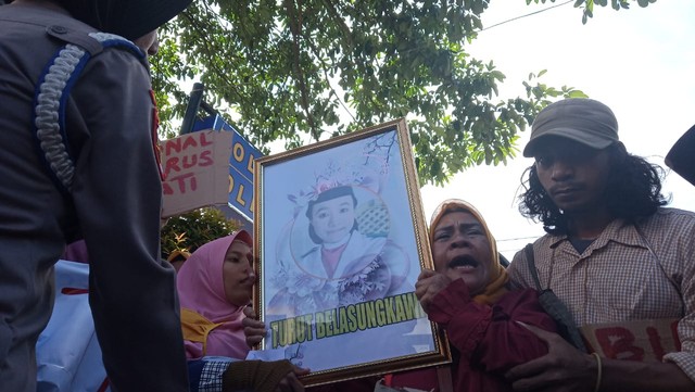 Seorang demonstran membawa potret Gamaria Kumala atau Kiki, korban pembunuhan oleh Ronal. Foto: Rizal Syam/cermat