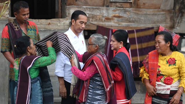 Presiden Joko Widodo (tengah) bersama Ibu Negara Iriana Joko Widodo (kedua kanan) mengenakan kain ulos saat mengunjungi kawasan kerajinan tenun ulos di Samosir, Sumut. Foto: ANTARA FOTO/Akbar Nugroho Gumay