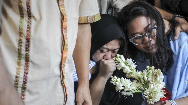Istri dan anak selebriti almarhum Agung Santoso atau Agung Hercules, Mira Rahayu (kedua kanan) dan Mia Aulia Gaswara (kanan) menangis saat menyaksikan pemakaman di TPU Cikutra, Bandung, Jawa Barat, Jumat (2/8). Foto: ANTARA FOTO/Novrian Arbi