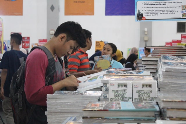 Seorang pemuda sedang membaca buku. Jumat (2/8/2019). Foto: Birgita.