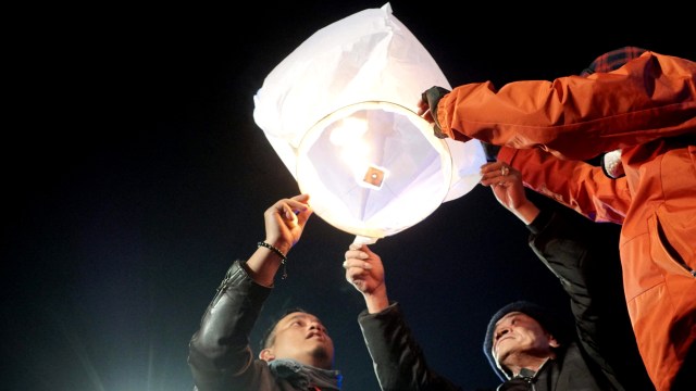 Wisatawan menyalakan lampion saat mengikuti malam lampion di Dieng Culture Festival 2019. Foto: Helmi Afandi Abdullah/kumparan