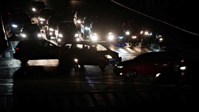 Sebuah kendaraan melintas di kawasan jalan Thamrin, Jakarta Pusat, yang terpantau gelap. Foto: Jamal Ramadhan/kumparan