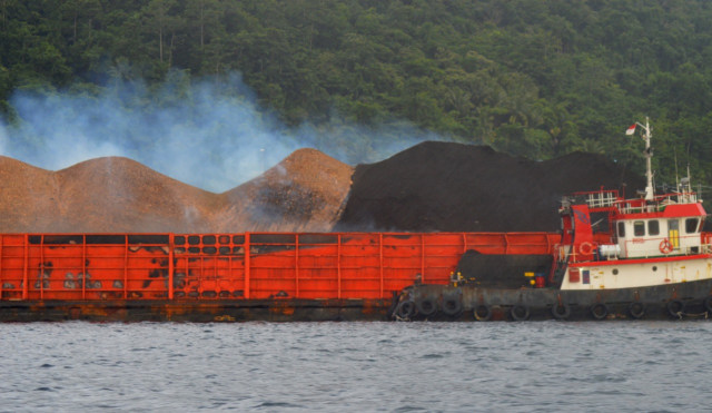 Gundukan batubara di atas kapal tongkang diduga terbakar saat tahap penurunan di Pelabuhan Pembangkit Listrik Tenaga Uap (PLTU) di kawasan Rum Balibunga, Tidore Utara, Kota Tidore Kepulauan, Maluku Utara. Foto: Olis/cermat