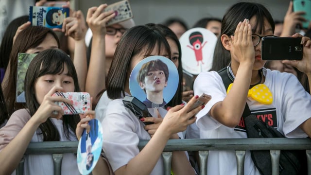 Ilustrasi penonton membawa foto idola K-pop. Foto: Getty Images