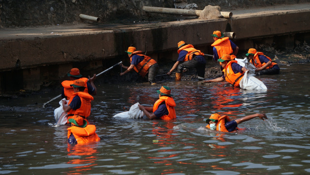 Suasana saat Petugas Dinas Lingkungan Hidup membersihkan sampah di bantaran Kali Ciliwung yang terletak di belakang Kantor Kementerian Luar Negeri, Jakarta, Jumat (9/8). Foto: Fanny Kusumawardhani/kumparan
