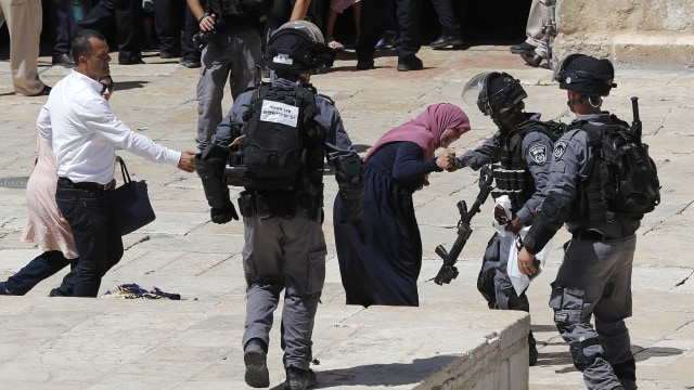 Seorang tentara Israel berkelahi dengan seorang warga Palestina di kompleks Masjid al-Aqsa di Kota Tua Yerusalem, Minggu (11/8). Foto: AFP/AHMAD GHARABLI
