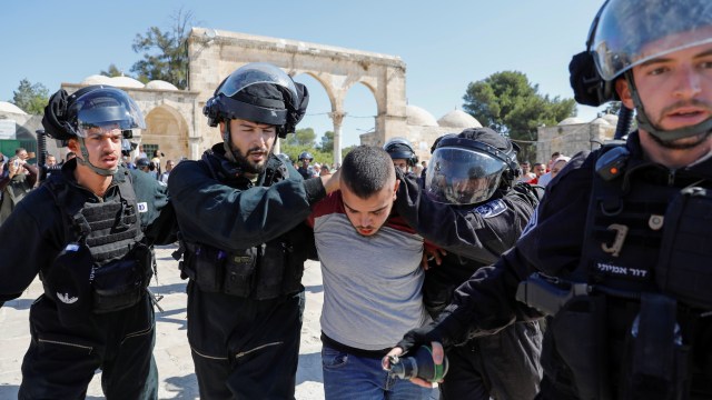 Tentara Israel mengamankan warga Palestina di kompleks Masjid al-Aqsa di Kota Tua Yerusalem, Minggu (11/8). Foto: AFP/AHMAD GHARABLI