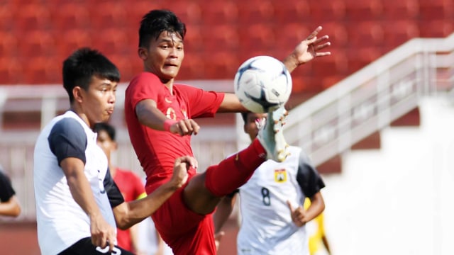 Pesepak bola Indonesia Sutan Zico (kanan) berebut bola dengan pesepak bola Laos Akkhom Thoranin (kiri) saat bertanding pada penyisihan Grup A Piala AFF U-18 2019 di Stadion Thong Nhat, Ho Chi Minh, Vietnam, Senin (12/8). Foto: ANTARA FOTO/Yusran Uccang