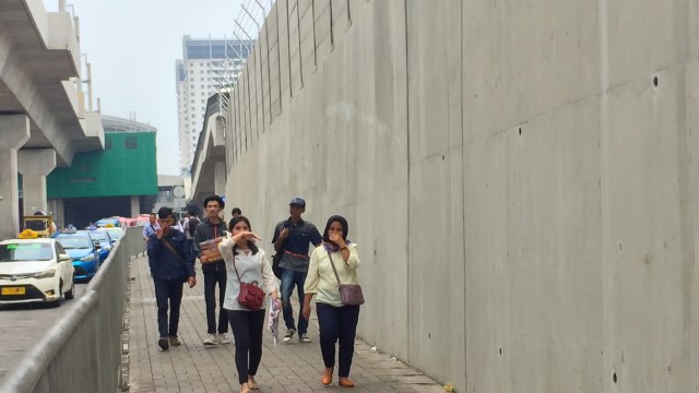 Warga Menutup Hidung Melewati Trotoar di Stasiun MRT Lebak Bulus yang Bau Pesing yang Menyengat. Foto: Andesta Herli Wijaya/ kumparan.
