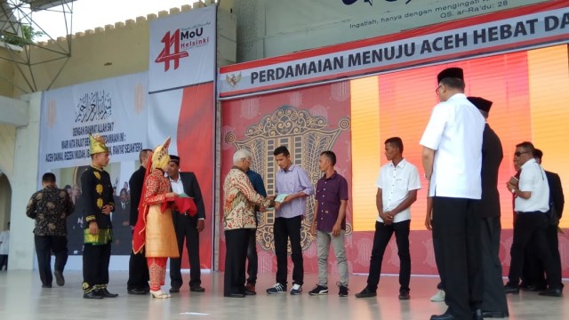 Penyerahan sertifikat tanah secara simbolis kepada mantan kombatan GAM, saat peringatan 14 tahun MoU Helsinki. Foto: Habil Razali/acehkini
