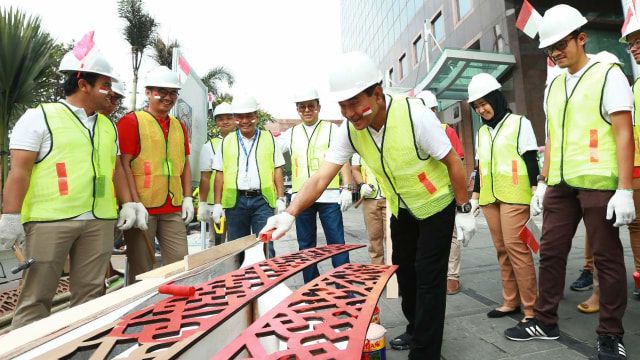 Direktur Utama Bank BRI, Suprajarto, ikut mengecat elemen 'Gapura Cinta Negeri' yang didirikan di Kantor Pusat Bank BRI di Jakarta. Foto: Dok. Bank BRI
