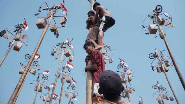 Warga mengikuti lomba panjat pinang kolosal dalam rangka HUT ke-74 Kemerdekaan RI di Pantai Karnaval, Ancol, Jakarta. Foto: Helmi Afandi Abdullah/kumparan