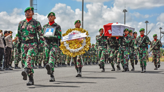 Anggota TNI mengusung peti jenazah Praka Anumerta Sirwandi M. Sahidillah yang tiba di Lombok International Airport di Praya, Lombok Tengah, NTB, Senin (19/8). Foto: ANTARA FOTO/Ahmad Subaidi
