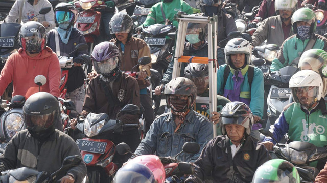 Seorang pengendara motor membawa tangga saat terjebak macet di kawasan Jalan Gatot Subroto, Jakarta. Foto: Iqbal Firdaus/kumparan