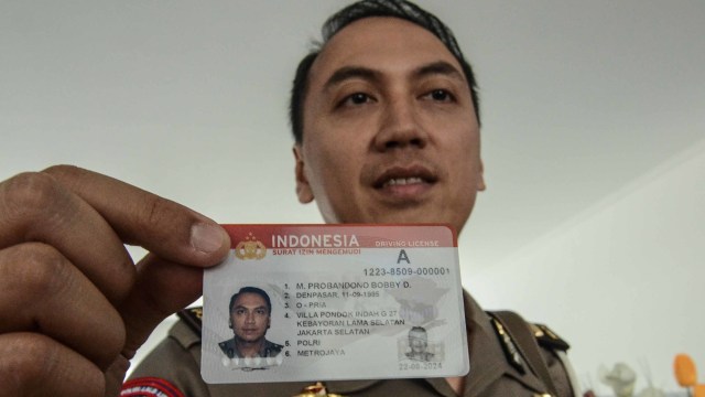 Polisi menunjukkan kartu Smart SIM (Surat Izin Mengemudi) di Gedung Satuan Penyelenggara Administrasi (Satpas) dan gerai SIM di Kabupaten Bekasi, Cikarang, Jawa Barat, Kamis (22/8). Foto: ANTARA FOTO/Fakhri Hermansyah