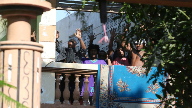 Sejumlah orang keluar dan mengangkat tangannya di Asrama Mahasiswa Papua di Jalan Kalasan 10, Surabaya, Jawa Timur, Sabtu (17/8/2019). Foto: ANTARA FOTO/Didik Suhartono