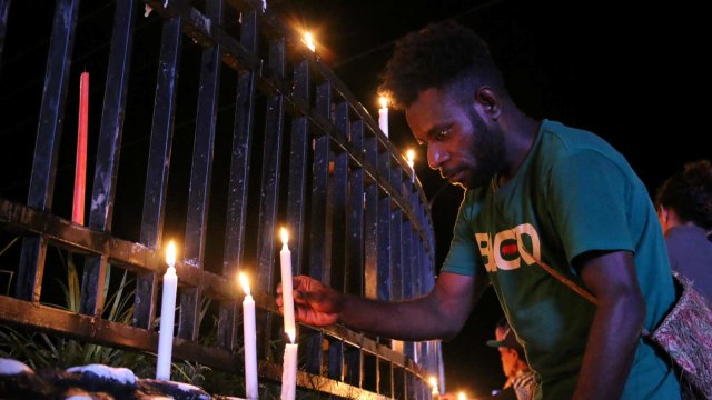 Warga Papua menyalakan lilin dalam aksi damai di Bundaran Tugu Perdamaian Timika Indah, Mimika, 19 Agustus 2019. Foto: ANTARA/Sevianto Pakiding