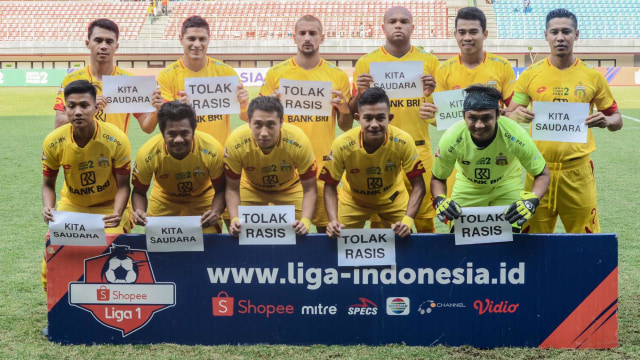 Sejumlah pemain Bhayangkara FC  berfoto dengan poster seruan tolak rasisme saat lanjutan Liga 1 di Stadion Patriot Chandrabhaga, Bekasi, Jawa Barat, Selasa (20/8/2019). Foto: ANTARA FOTO/ Fakhri Hermansyah