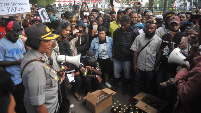 Mahasiswa Papua mengembalikan dua dus minuman beralkohol yang dikirim polisi. Foto: FRI-WP