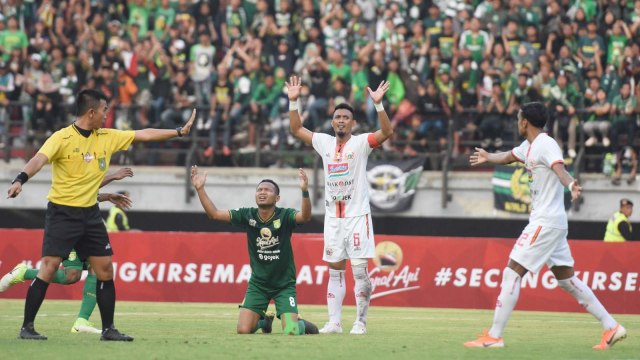 Wasit Aprisman Aranda (kiri) menunjuk titik putih usai pelanggaran yang dilakukan pesepak bola Persija Jakarta dalam lanjutan Liga 1 Indonesia di Stadion Gelora Bung Tomo, Surabaya, Jawa Timur. Foto: ANTARA FOTO/M Risyal Hidayat
