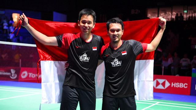 Ganda Putra Indonesia Hendra Setiawan (kiri) dan Mohammad Ahsan membawa bendera Merah Putih usai pertandingan babak final Kejuaraan Dunia Bulu Tangkis 2019 di St. Jakobshalle, Basel, Swiss. Foto: ANTARA FOTO/Hafidz Mubarak