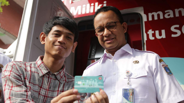 Gubernur DKI Jakarta Anies Baswedan (kanan) dan seorang penyanda disabilitas menunjukkan Kartu Penyandang Disabilitas Jakarta (KPDJ) di Gelanggang Olahraga Matraman, Jakarta. Foto: Helmi Afandi Abdullah/kumparan