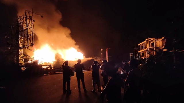 Warga menyaksikan bangunan yang terbakar saat berlangsungnya aksi unjuk rasa di Jayapura, Papua. Foto: ANTARA FOTO/Indrayadi TH