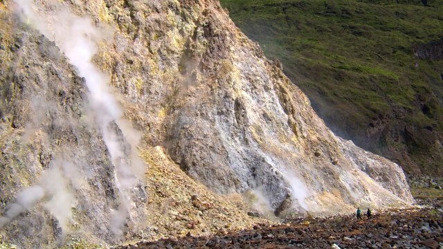 Tampak perbandingan betapa kecilnya manusia saat berjalan di sisi salah satu dinding kaldera yang masih mengeluarkan asap solfatara, di dalam dasar kaldera Tambora. Hal ini mendakan bahwa Gunung Tambora masih menunjukkan aktivitas vulkaniknya. Foto: Harley Sastha