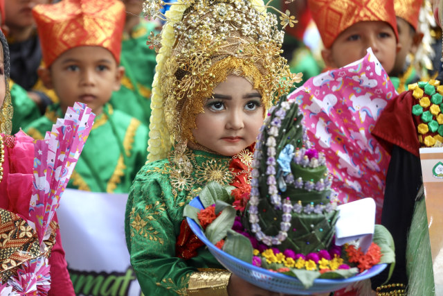 Peserta pawai siswa PAUD membawa sirih (ba ranup) sebagai simbol memuliakan tamu di Aceh dalam pawai merayakan 1 Muharam 1441 Hijriah di Kota Banda Aceh, Minggu (1/9). Foto: Suparta/acehkini