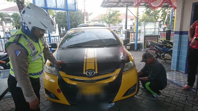 Mobil sedan yang terlibat aksi pengejaran saat menerobos razia lalu lintas diamankan di Pos Polisi Barisan Kota Sampang, Kamis (5/9/2019) sore. (Ryan Hariyanto/MM).