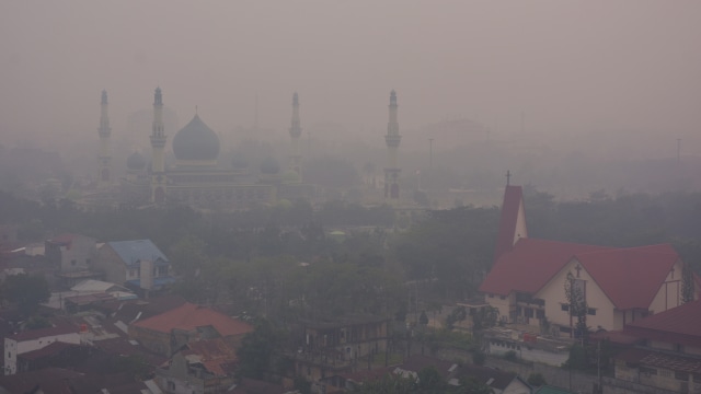 Masjid Raya An-Nur tampak samar-samar ketika kabut asap kebakaran hutan dan lahan (Karhutla) menyelimuti Kota Pekanbaru, Riau, Selasa (10/9). Foto: ANTARA FOTO/FB Anggoro