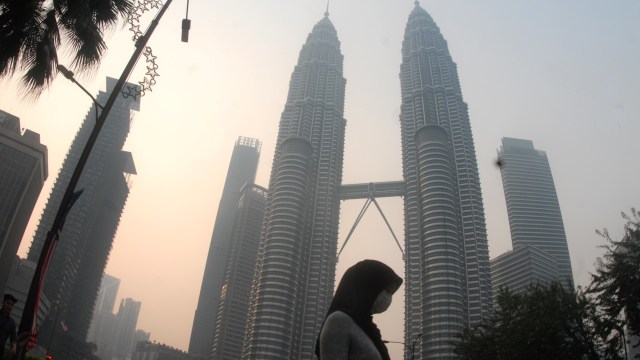 Warga beraktivitas dengan mengenakan masker di dekat menara kembar Petronas, Kuala Lumpur, Malaysia, Selasa (10/9/2019). Foto: ANTARA FOTO/Rafiuddin Abdul Rahman
