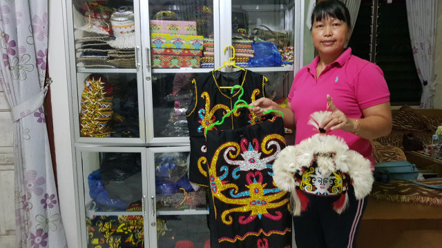 Evi, pengrajin asli Suku Dayak dengan berbagai kerajinan khas Suku Dayak yang dibuatnya | Photo by Charles (Karja)