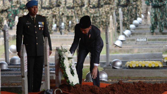 Presiden Joko Widodo (kanan) meletakkan karangan bunga di makam almarhum Presiden ke-3 Republik Indonesia BJ Habibie. Foto: Nugroho Sejati/kumparan