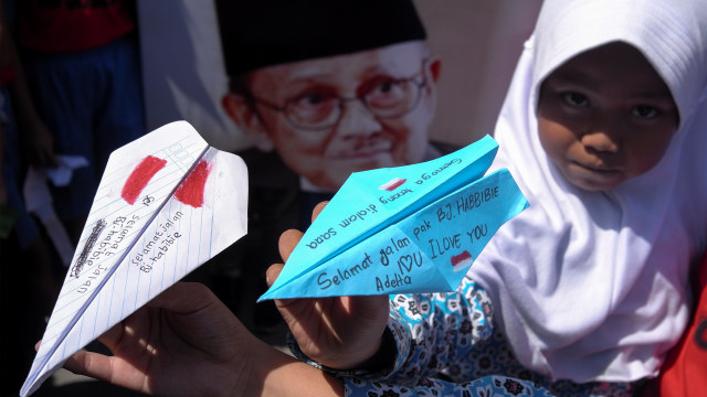 Siswa SD Negeri Joglo Solo menunjukkan pesawat kertas lipat yang dibuatnya untuk acara Doa Bersama bagi almarhum Presiden ke-3 Republik Indonesia BJ Habibie di Solo, Jawa Tengah, Kamis (12/9/2019). Foto: ANTARA FOTO/Maulana Surya