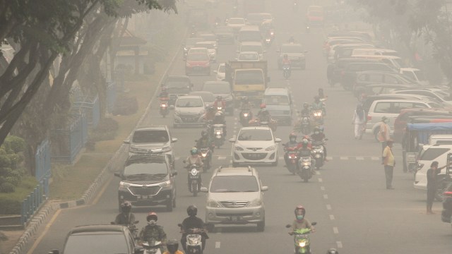 Pengendara kendaraan bermotor menembus kabut asap pekat dampak dari kebekaran hutan dan lahan di Pekanbaru, Riau, Jumat (13/9). Foto: ANTARA FOTO/Rony Muharrman