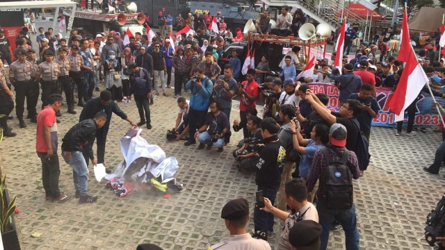Massa yang menggelar aksi di depan KPK membakar poster dan spanduk pada Sabtu (14/9/2019). Foto: Andreas Ricky Febrian/kumparan