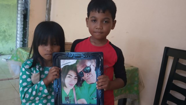 Kedua anak dari Lily dan Mahrus. Mereka tampak memegang bingkai foto orang tuanya. Foto: Rizal Syam/cermat