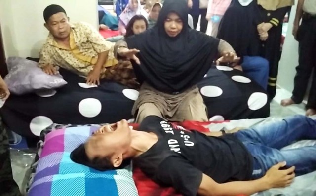Ningsih Tinampi mengobati salah satu pasiennya (foto: Moch Rois/jatimnow.com)