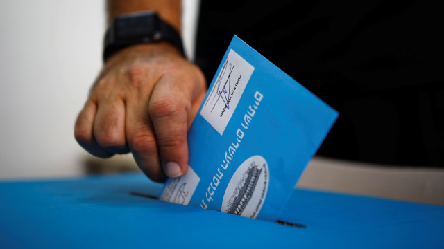Seorang pria memberikan suaranya saat pemilihan parlemen Israel, di sebuah TPS di Tel Aviv, Israel Selasa (17/9/2019). Foto: REUTERS/Corinna Kern
