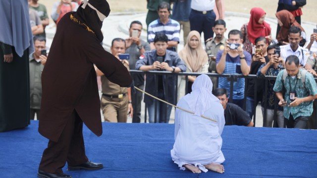 Pelanggar syariat Islam menjalani hukum cambuk yang digelar di Taman Bustanussalatin, Kota Banda Aceh, Kamis (19/9). Foto: Suparta/acehkini
