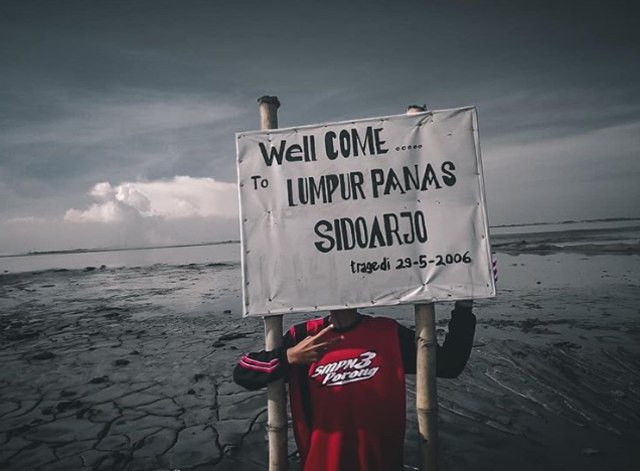 Seorang anak berpose di depan lumpur panas Sidoarjo | Photo by @brynnn on Instagram